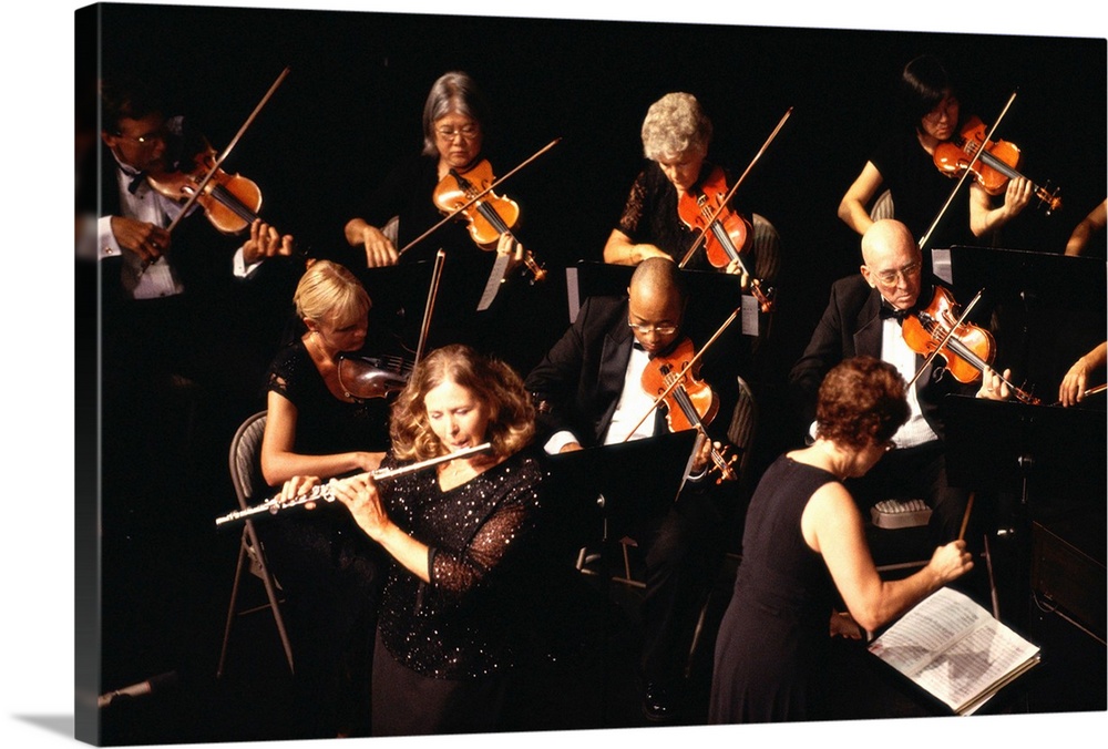 Mature woman performing flute solo with orchestra, overhead view