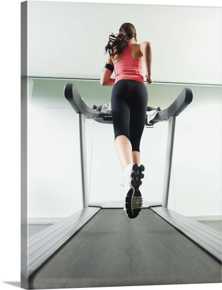 Mixed race woman running on treadmill