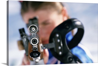 Woman shooting rifle in biathlon (focus on nozzle)