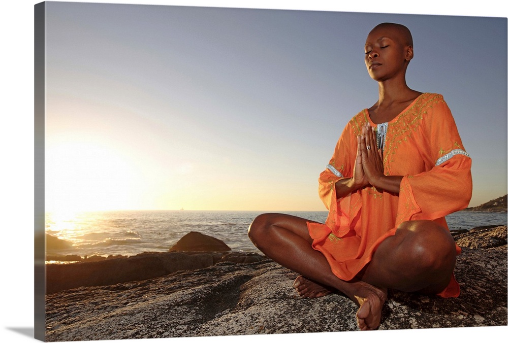 Woman sitting in meditative yoga position at sunset, Cape Town, Western Cape Province, South Africa