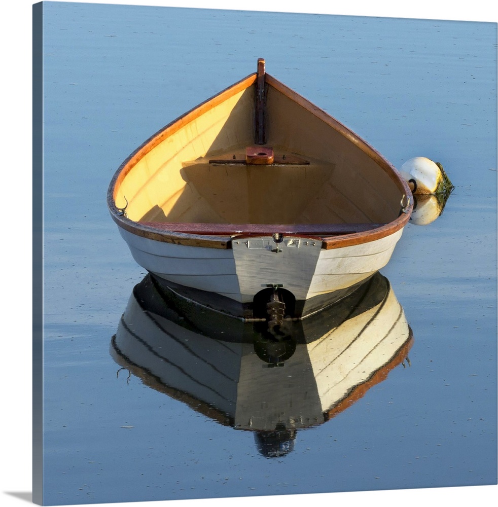 beautiful wooden skiff (boat, dinghy) photographed from the back with a reflection in water - a buoy is next to the boat