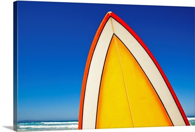 Yellow and orange retro surfboard at beach, Eyre Peninsula, South Australia.