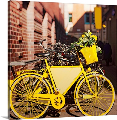 Yellow bike with sunflowers parked outside.