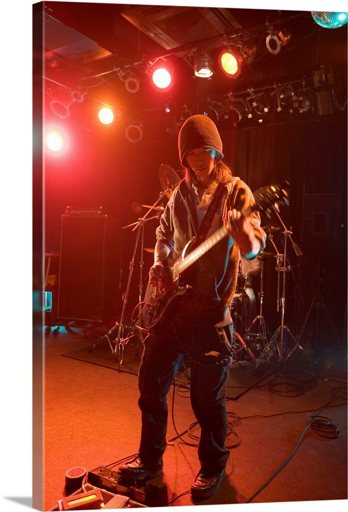 Young man playing electric guitar on stage