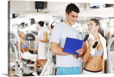 Young woman with personal trainer in a gym.