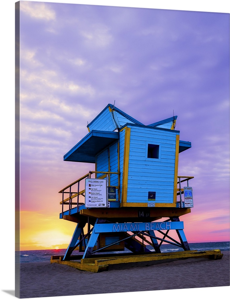 The sun burns through clouds during another beautiful sunrise over Miami Beach's retro 14th Street lifeguard station.