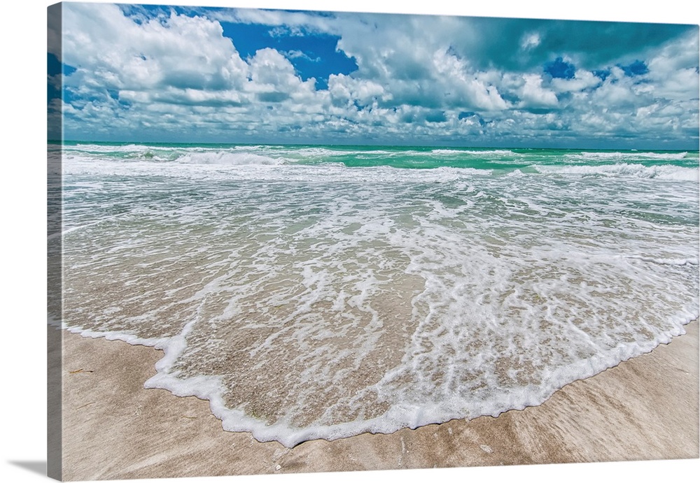 Gentle waves wash onto a sandy beach in this summery photography