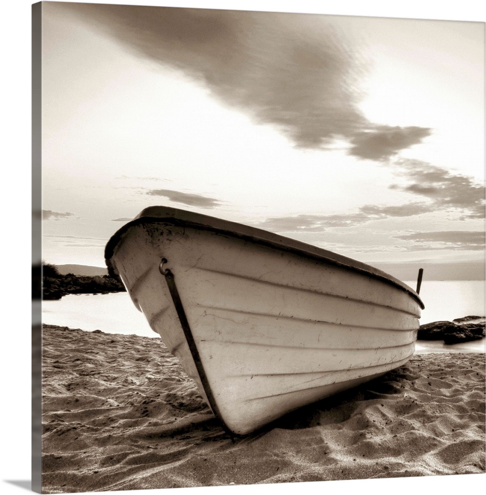 A square image of a small white boat pulled up onto a sandy beach with a dramatic line of clouds above.