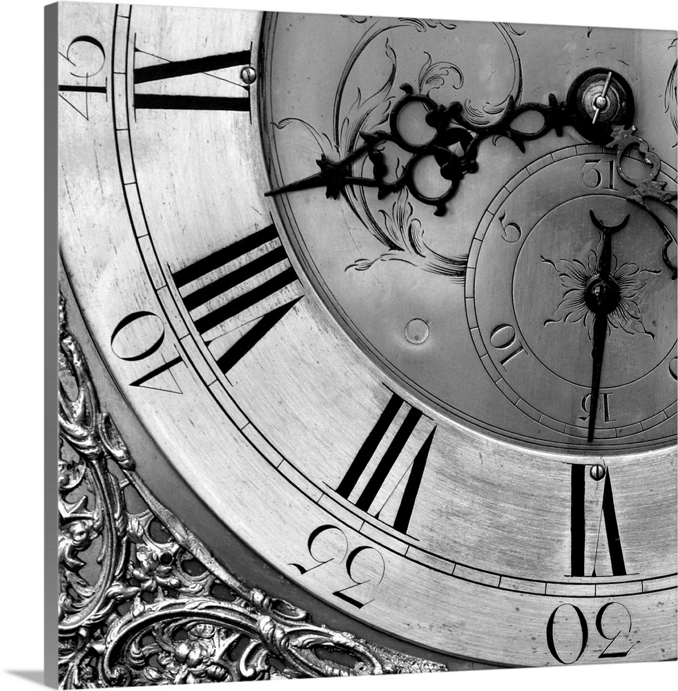 Square black and white photograph of the details of a clock, focusing on the hands and numbers.