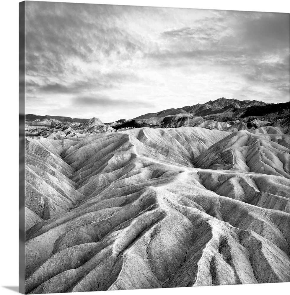 Square black and white photograph of contrasting mountains ridges.