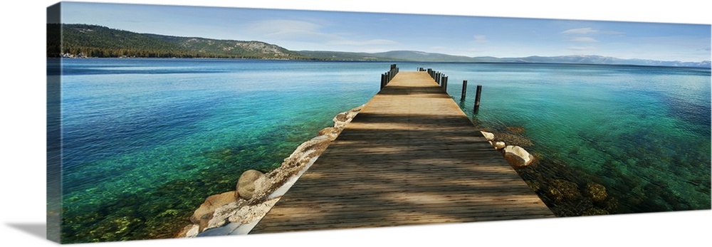 A photograph of a dock jetting out over vibrant crystal water in a tropical paradise.