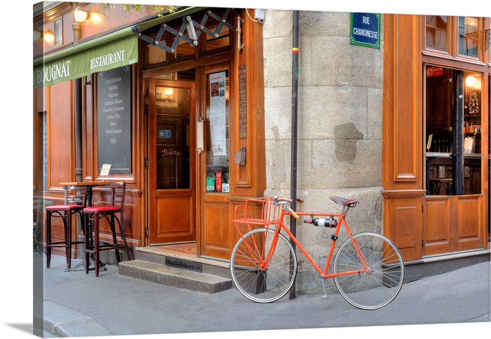 An orange bicycle leaning on the corner of a restaurant on Rue Chanoinesse in Paris.