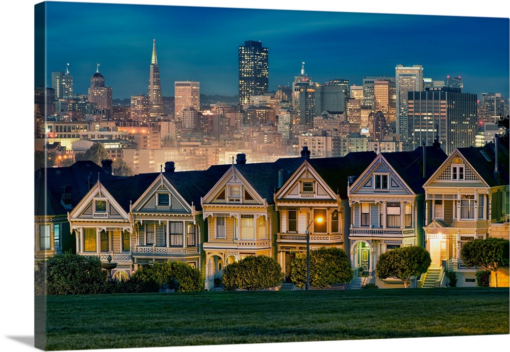 Photograph of colorful row houses in San Francisco at twilight with the city skyline in the background.