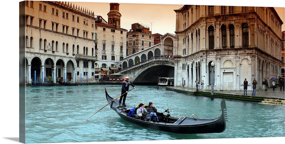Panoramic image of a couple riding in a gondola in the canals of Venice, Italy.