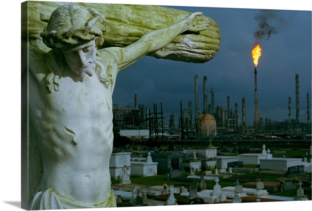 A crucifixion statue in Holy Rosary Cemetery overlooks petrochemical plants mas sed upriver from New Orleans to Baton Roug...