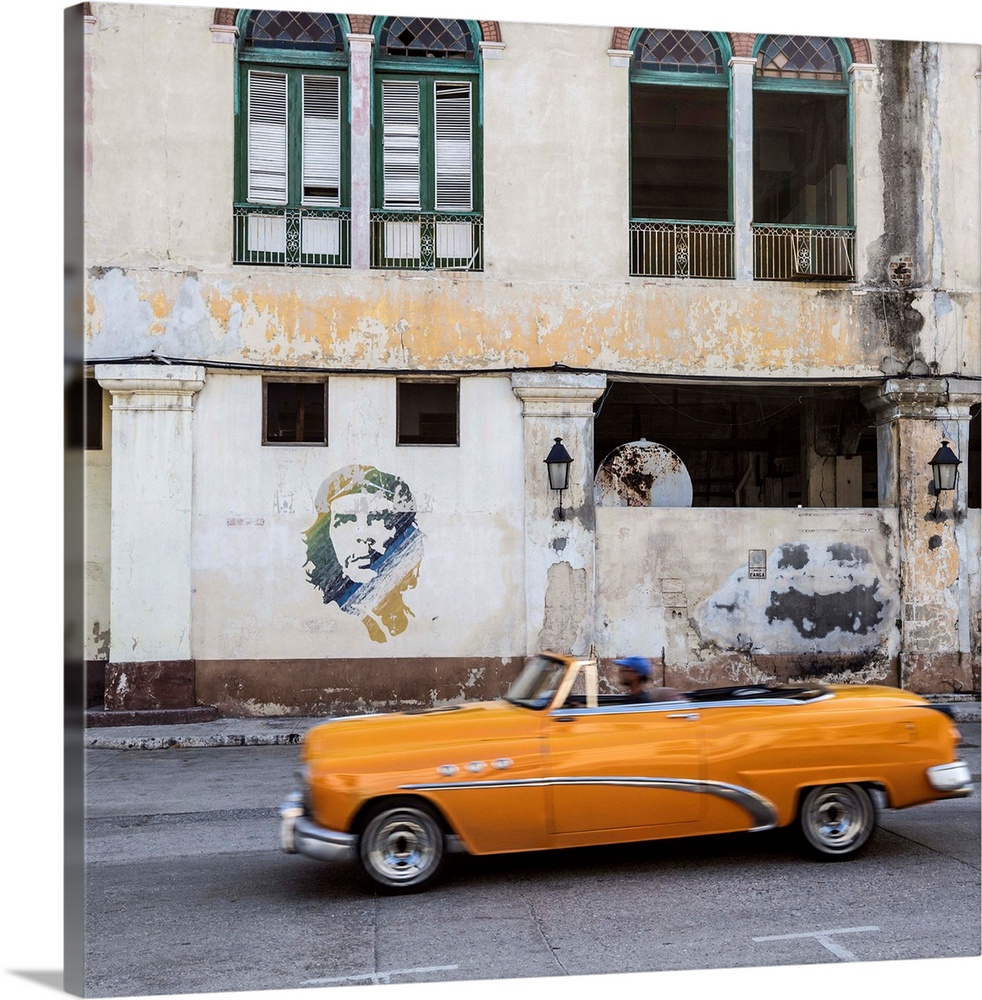 50's Classic American car passing a mural of Che Guevara, Habana Vieja, Havana, Cuba.