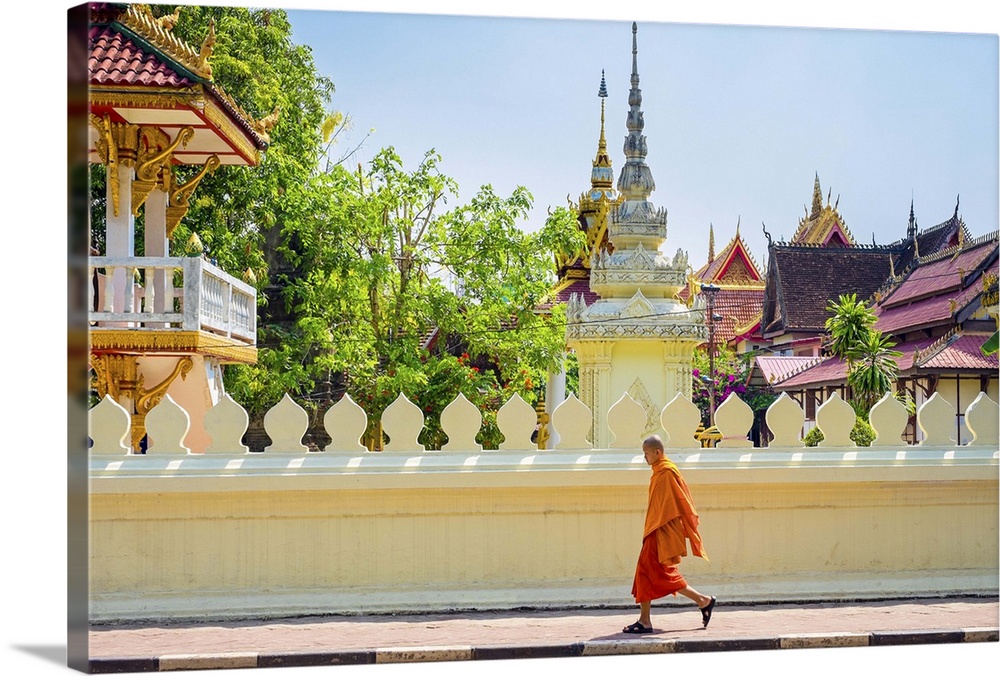 A buddhist monk walks past Wat Si Saket (Wat Sisaket) temple in central Vientiane, Laos.