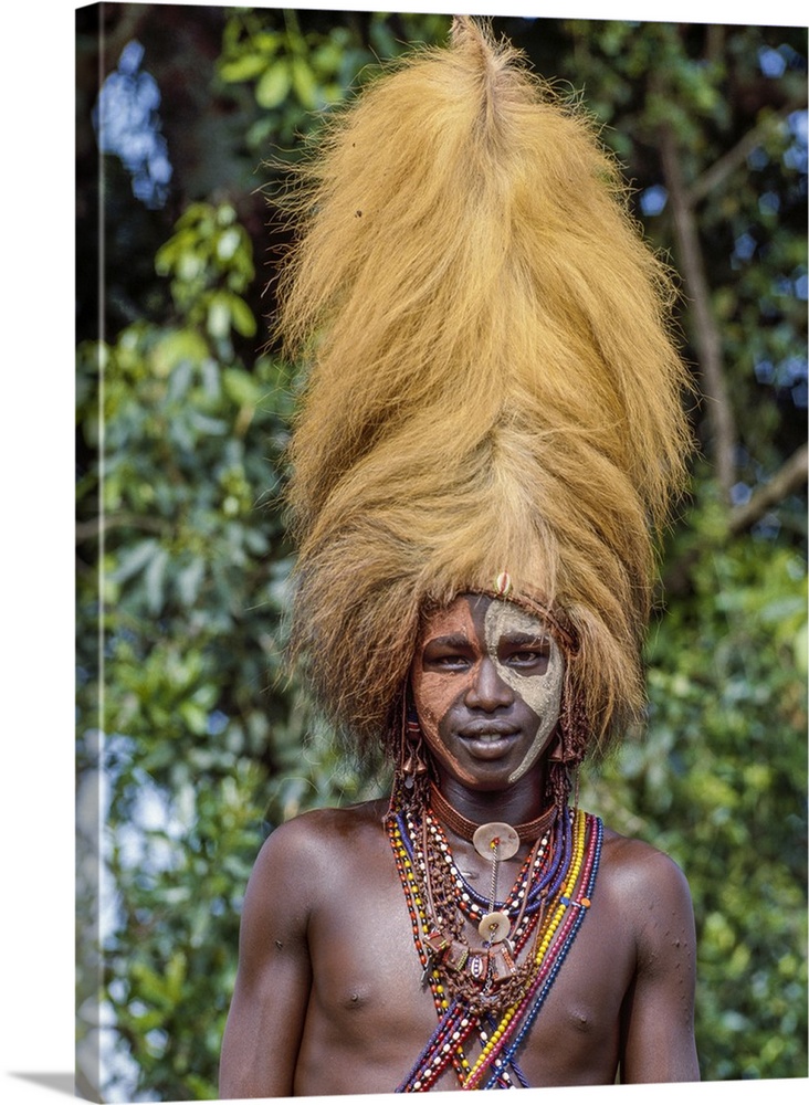 Kenya, Kilgoris County, Oloololo. A Maasai warrior wears a headdress made from a lion's mane during an eunoto ceremony.