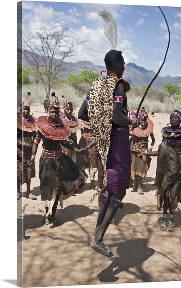 A Pokot warrior wearing a leopard skin jumps high in the air surrounded by women to celebrate an Atelo ceremony. The Pokot...