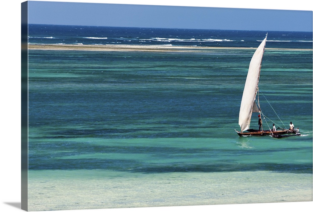 A traditional outrigger canoe sails close to the shore at Diani Beach.