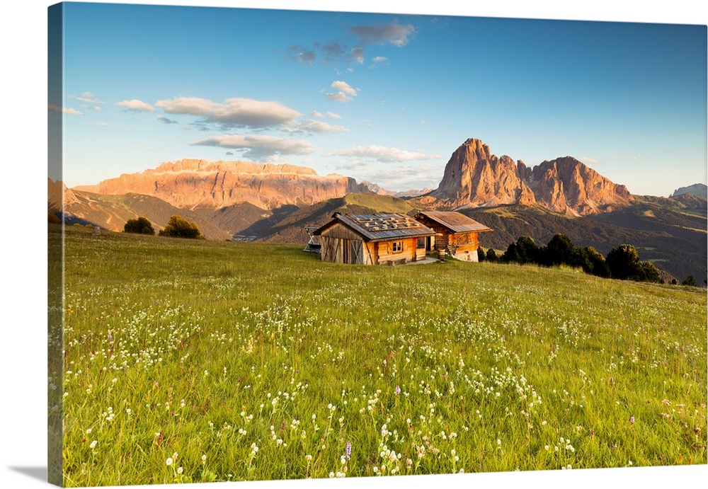 A view of an alpine hut during a sunset in Val Gardena with the Sella Group and the Langkofel in the background, Bolzano p...