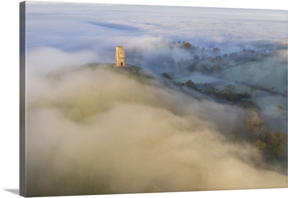 Aerial view of Glastonbury Tor surrounded by morning mist, Glastonbury, Somerset, England