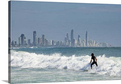 Australia, Surfer riding waves with Surfers Paradise skyline in background
