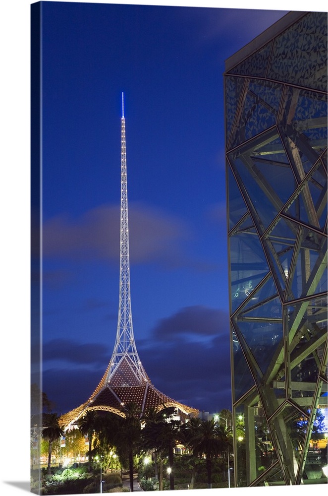 Australia, Victoria, Melbourne. Glass and steel architecture of Federation Square with the spire of the Theatres Building ...