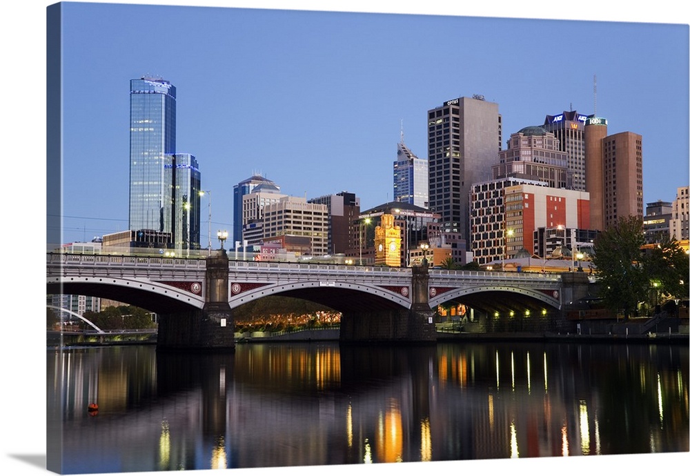 Australia, Victoria, Melbourne. Princes Bridge on the Yarra River, with the city skyline at dusk.