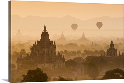 Bagan, Mandalay region, Myanmar, Pagodas and temples with balloons at sunrise