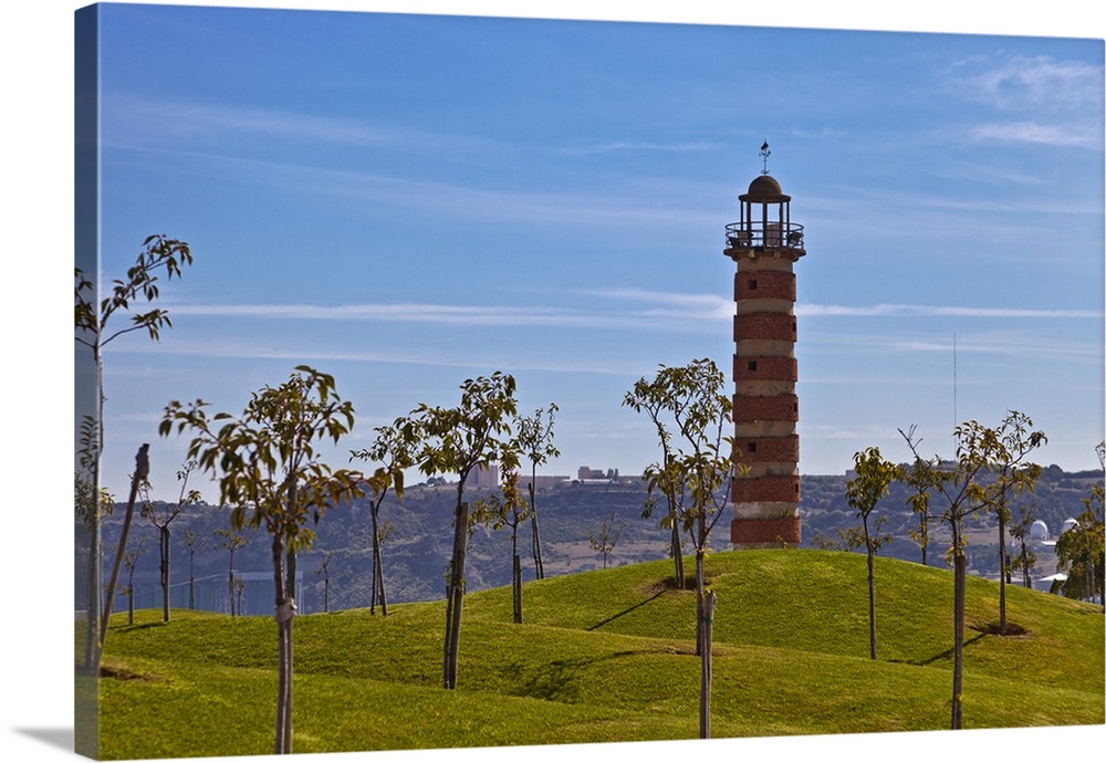 Belem Lighthouse at the entrance to the River Tagus Estuary with landscaped mounds and trees in the foreground in Ajuda, B...