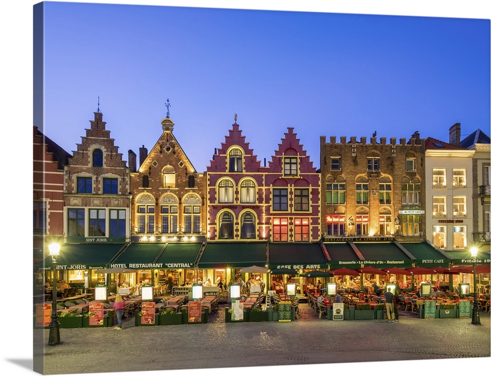 Belgium, West Flanders (Vlaanderen), Bruges (Brugge). Medieval guild houses and restaurants on Markt square at dusk.