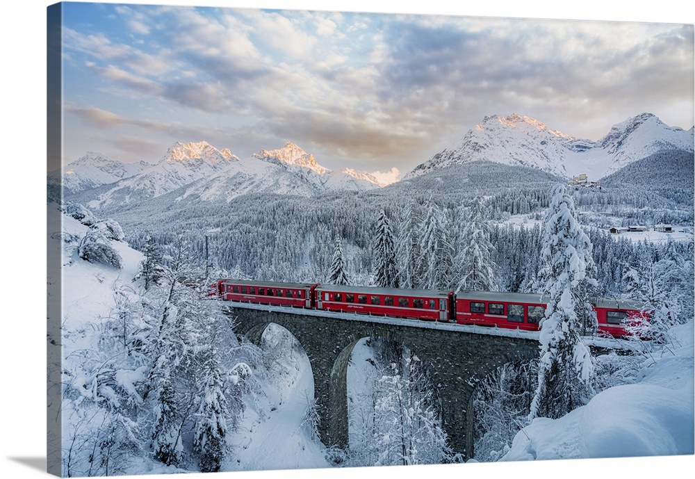 Bernina Express passes on a viaduct near Tarasp, Graubunden, Engadine, Switzerland. Graubunden, Western Europe, Switzerland.