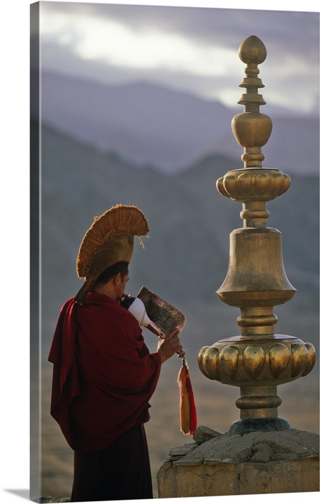 Buddhist Lama, making the call to prayer, Thikse Monastery, Ladakh, North West India.