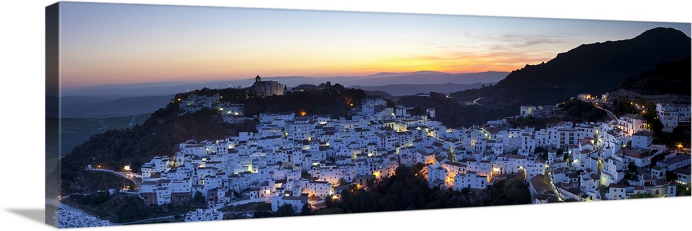 Elevated view over the dramatic hilltop village of Casares illuminated at sunset, Casares, Malaga Province, Andalusia, Spain