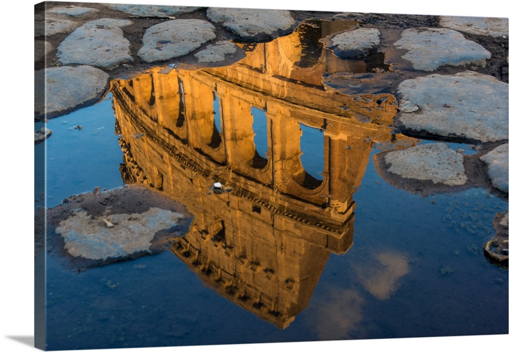 Colosseum or Coliseum reflected in a puddle at sunset, Rome, Lazio, Italy.