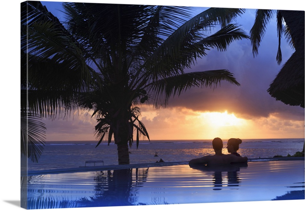 Tanzania. Zanzibar, Kigomani, Couple relaxing inside infinity pool overlooking the beach at luxurious resort (MR)