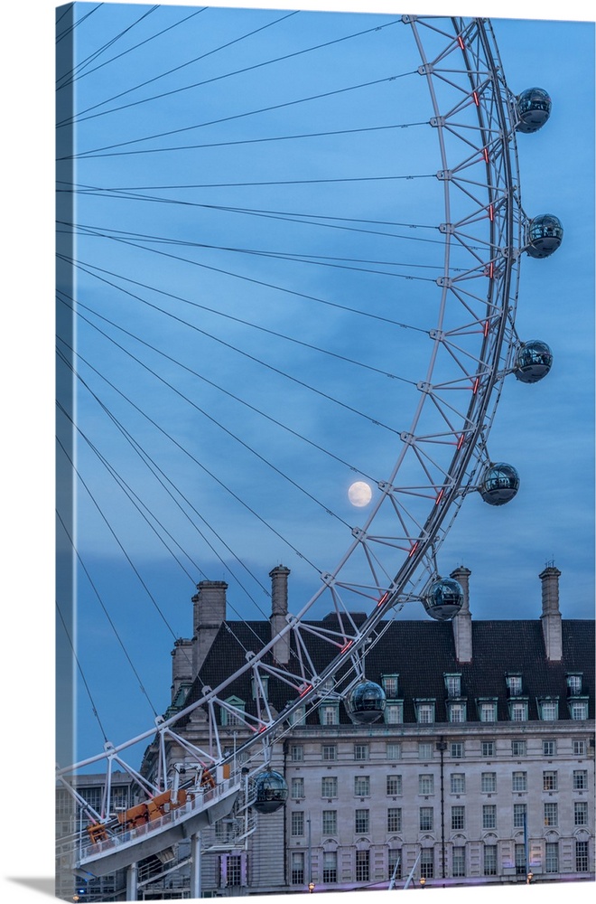 Details of London Eye ferris wheel with County Hall in background under the full moon, London, United Kingdom.