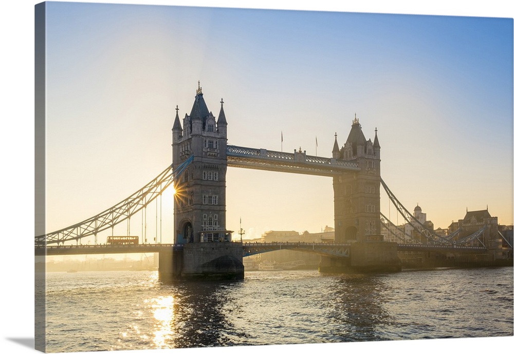 United Kingdom, England, London. Early morning sun rising behind Tower Bridge over the River Thames.
