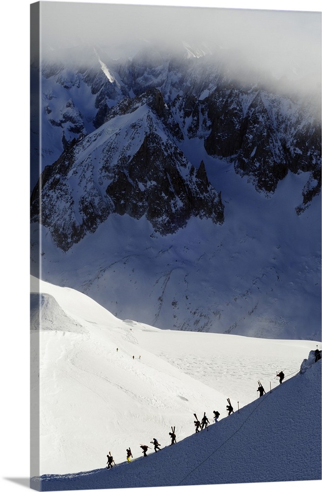 Europe, France, French Alps, Haute-Savoie, Chamonix, Aiguille du Midi, skiers walking down the ridge at the start of Valle...