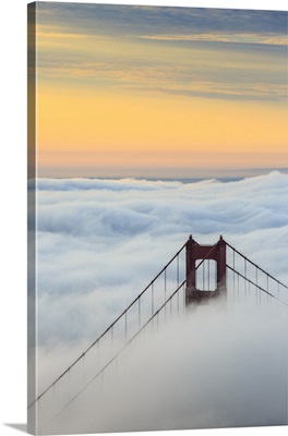 Golden Gate Bridge emerging from the morning fog at sunrise, San Francisco