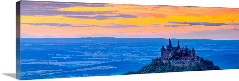 Elevated view towards Hohenzollern Castle and sourrounding countryside illuminated at sunset, Swabia, Baden Wuerttemberg, ...