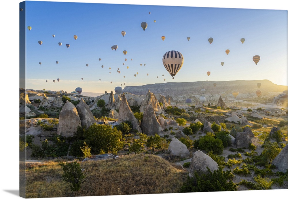 Aerial view of hot air balloon over rock formations at sunrise, Goreme, Goreme Historical National Park, Nevsehir District...