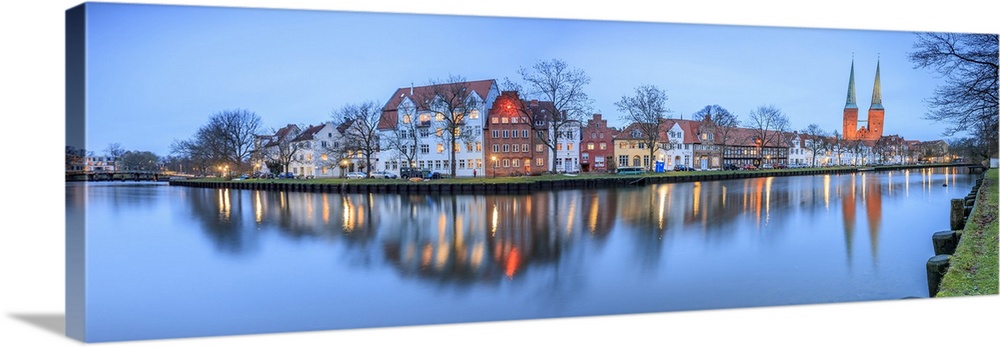 Panorama of typical houses and towers of the cathedral reflected in river Trave at dusk, Lubeck, Schleswig, Holstein, Germ...