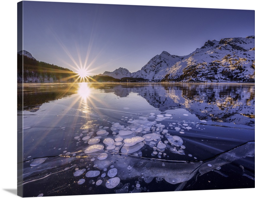 Ice bubbles trapped in the frozen Lake Sils, during a sunsetcanton of Graubunden, Engadine, Switzerland
