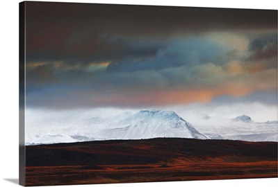 Iceland, Vesturland, Lava fields and snow covered mountains at sundown