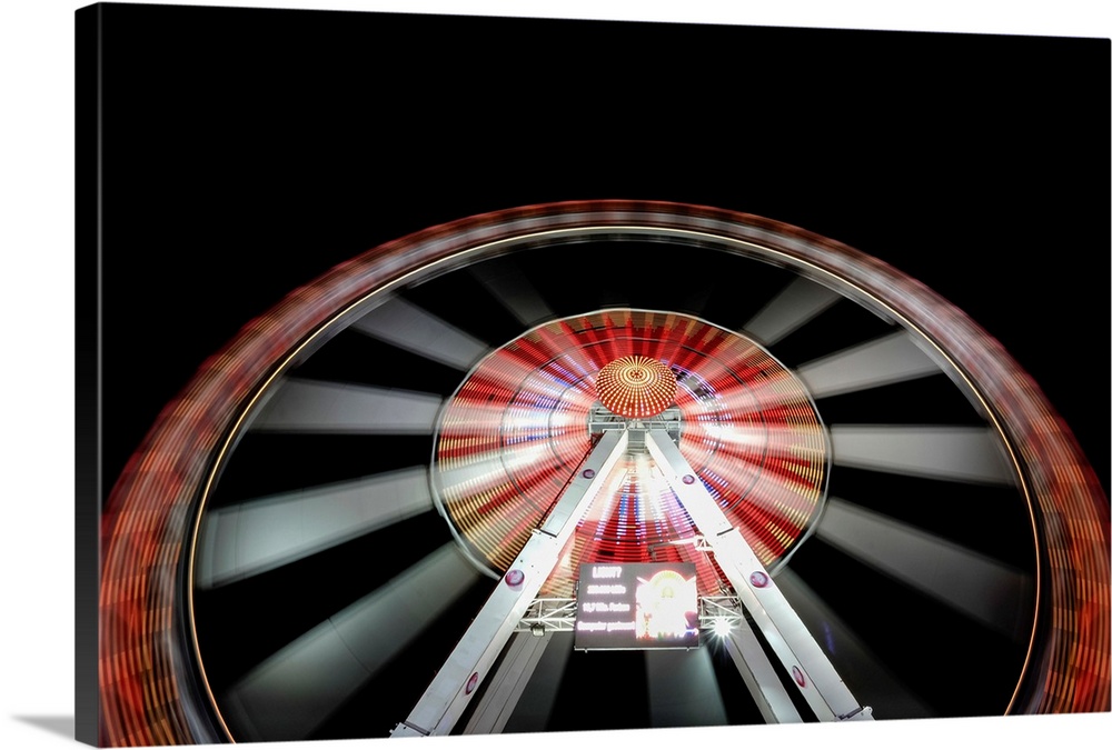 Long exposure of illuminated ferris wheel at Hamburger DOM funfair at night, St. Pauli, Hamburg, Germany.