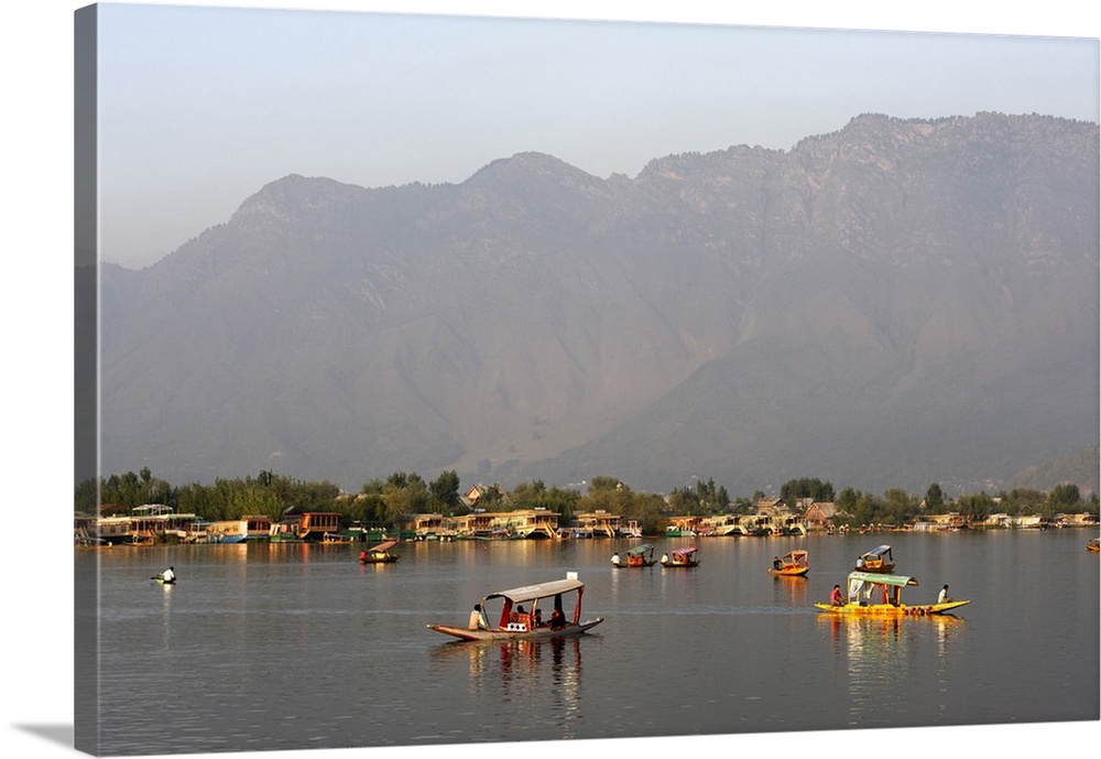 India, Jammu and Kashmir, Srinagar. Canopied shikaras, or small wooden ferry boats, and spacious houseboats add colour and...