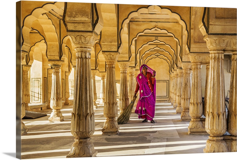India, Rajasthan, Jaipur, Amer. A Rajasthani woman sweeps the floor of a beautiful pavilion in the Amber Fort.