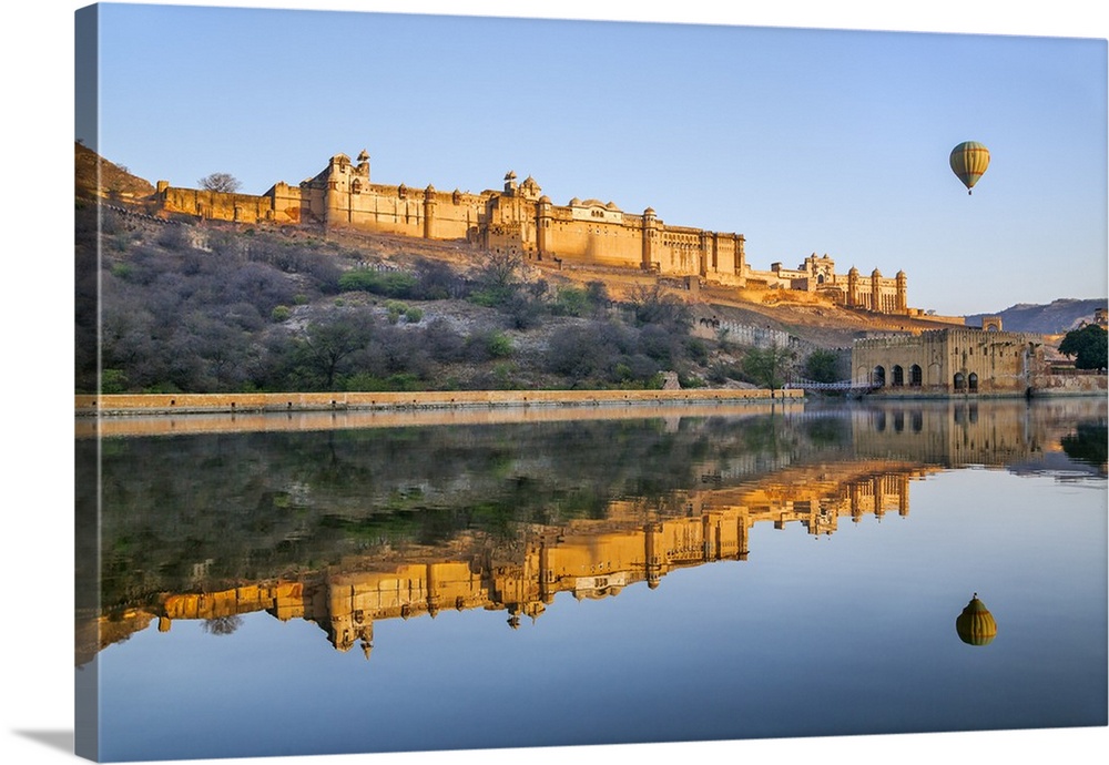 India, Rajasthan, Jaipur, Amer. The magnificent 16th century Amber Fort at sunrise with a hot air balloon aloft.